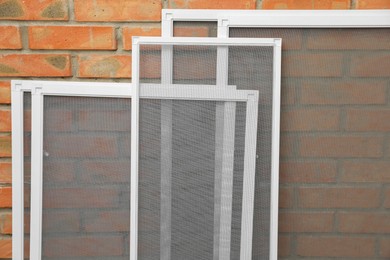 Set of window screens near brick wall