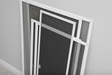 Photo of Set of window screens near light grey wall indoors, above view