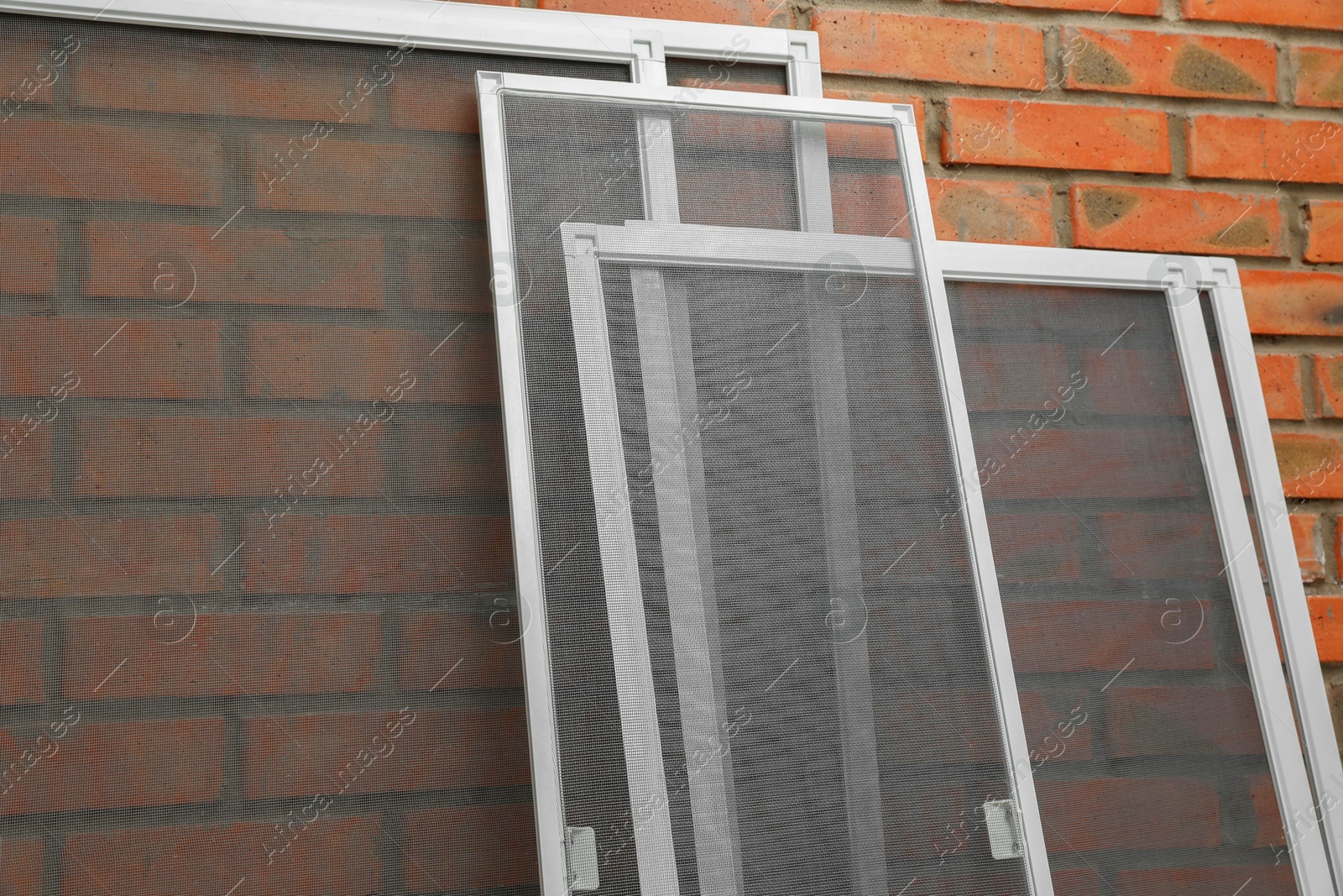 Photo of Set of window screens near brick wall