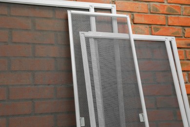 Set of window screens near brick wall