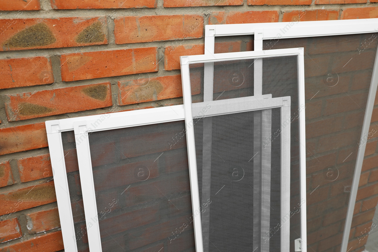 Photo of Set of window screens near brick wall