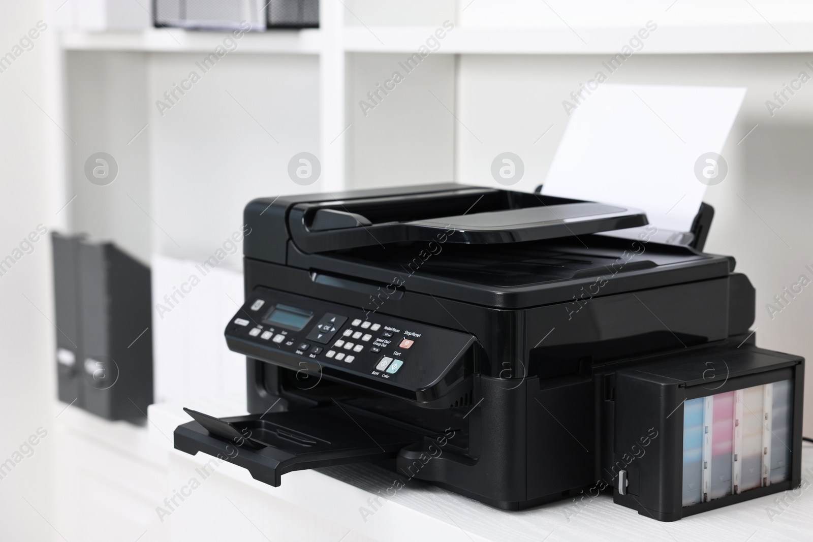 Photo of Modern printer with paper on table in office