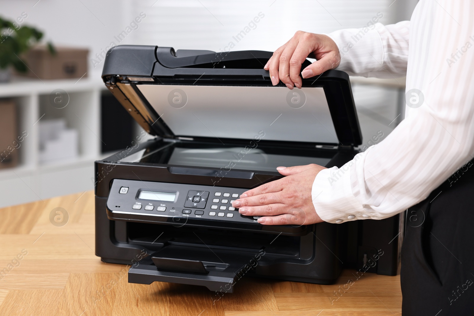 Photo of Woman using modern printer at workplace indoors, closeup