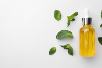 Bottle of essential oil and mint isolated on white, top view