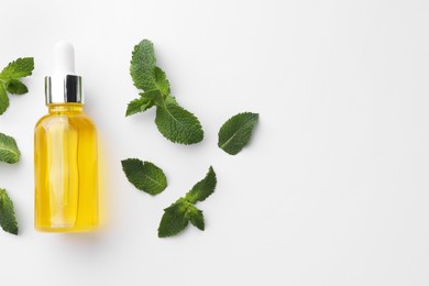 Photo of Bottle of essential oil and mint isolated on white, top view