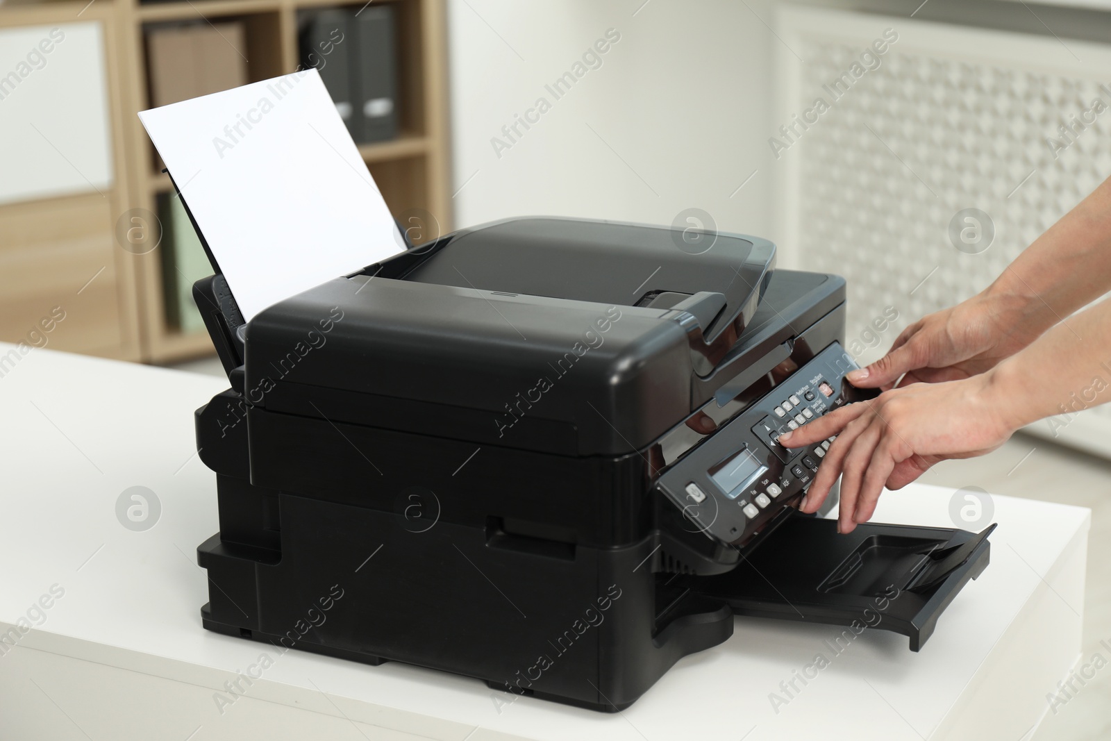 Photo of Woman using modern printer at workplace indoors, closeup