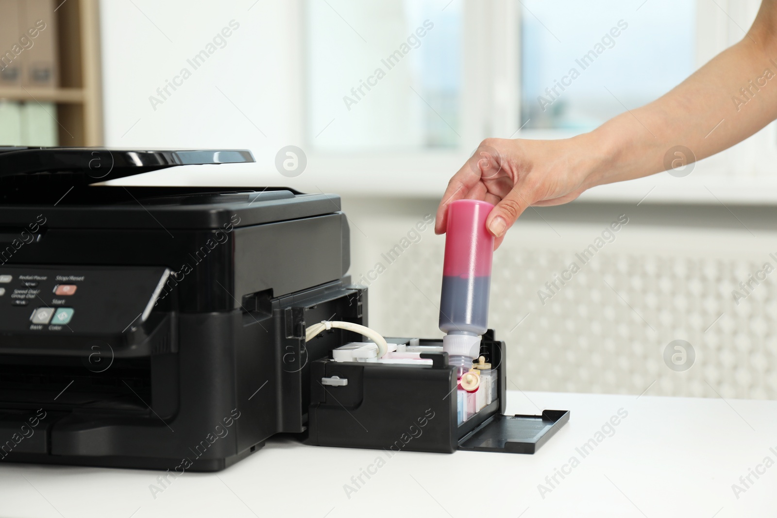 Photo of Woman refilling ink in modern printer at workplace indoors, closeup