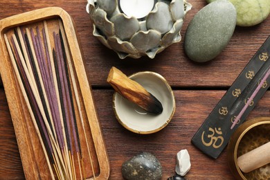 Photo of Flat lay composition with incense sticks on wooden table. Om ligature