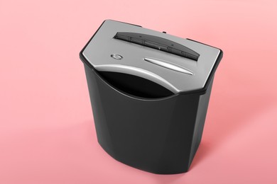 Photo of Paper shredder with basket on pink background