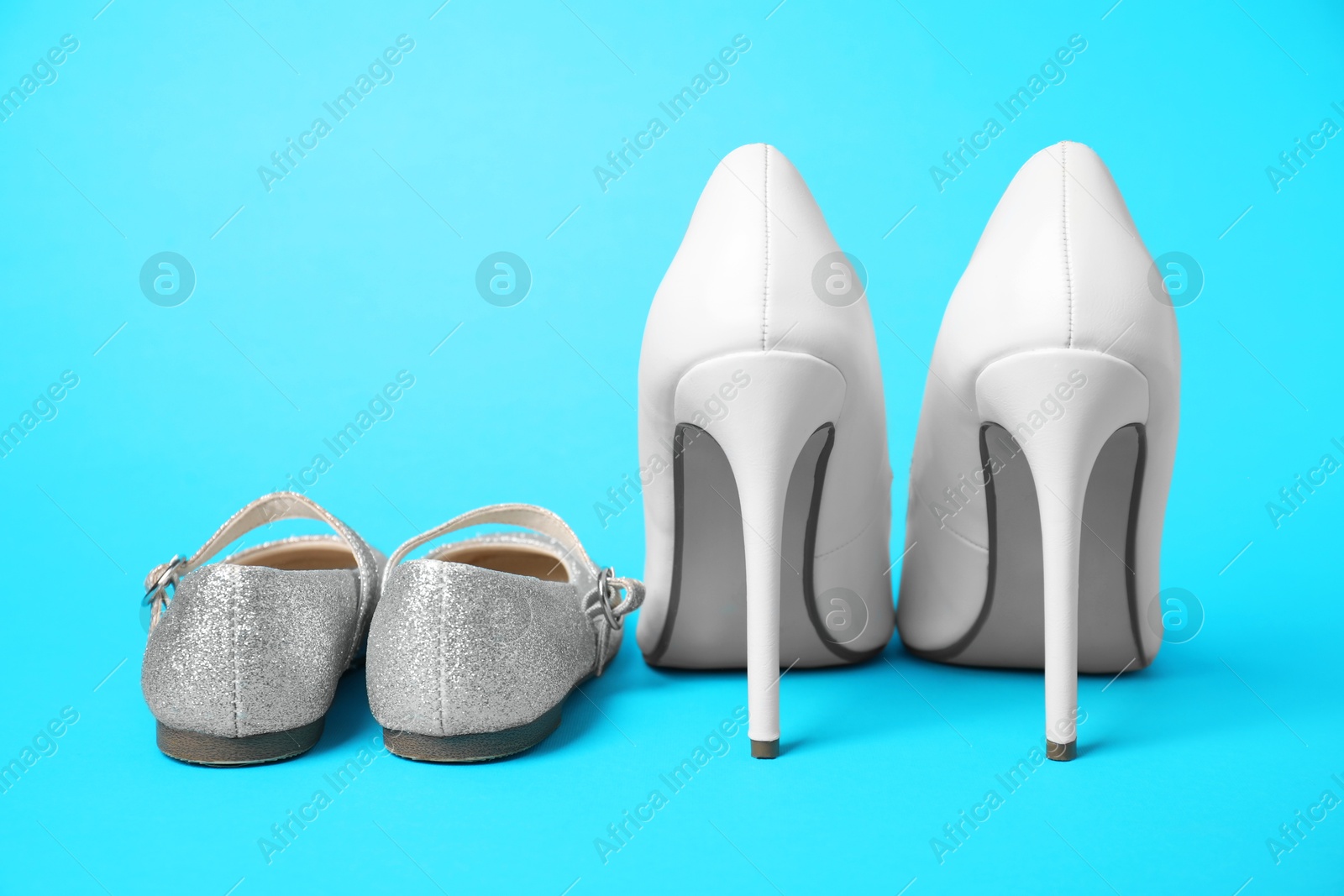 Photo of Big and small shoes on light blue background