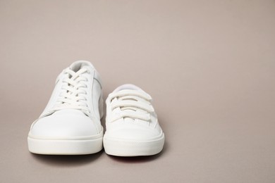 Photo of Big and small shoes on grey background, space for text