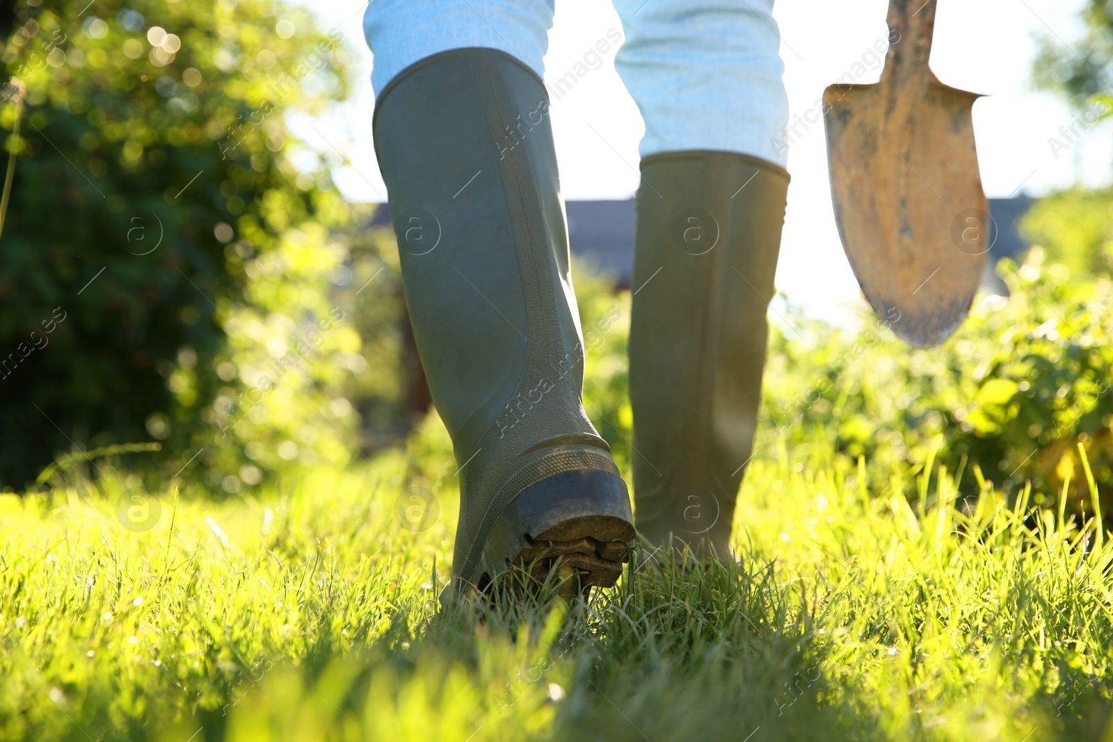 Photo of Farmer walking with shovel on sunny day, closeup