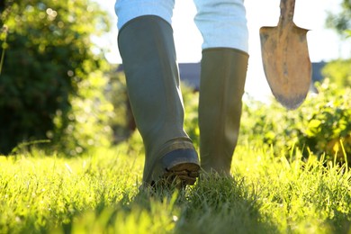 Farmer walking with shovel on sunny day, closeup