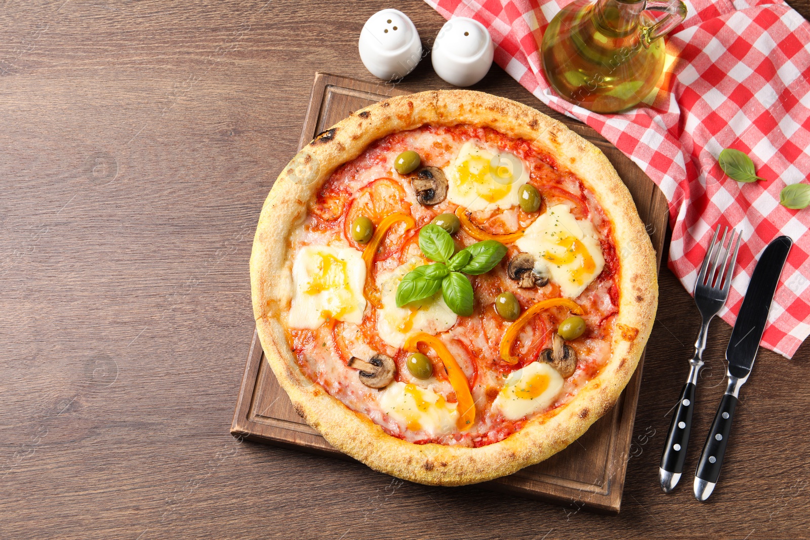 Photo of Delicious vegetarian pizza served on wooden table, flat lay