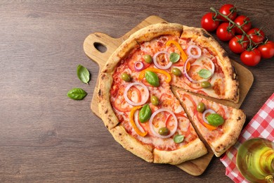 Photo of Delicious vegetarian pizza and tomatoes on wooden table, flat lay. Space for text