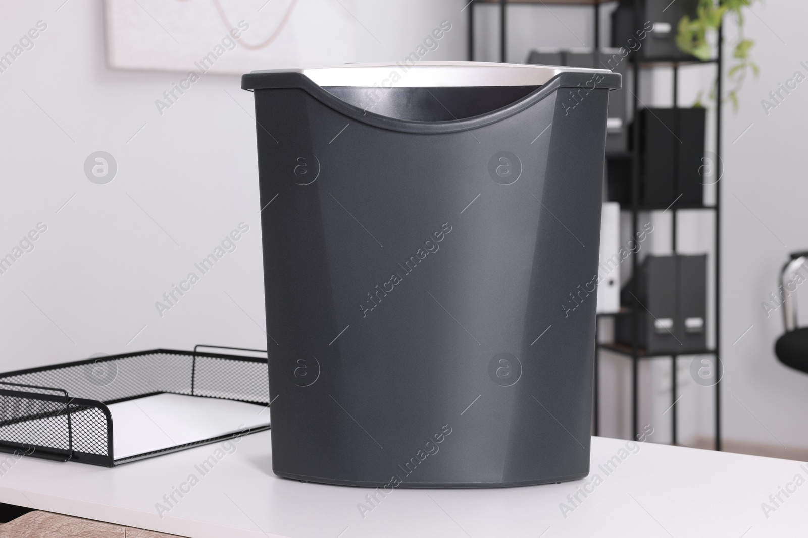 Photo of Paper shredder with bin on white table in office