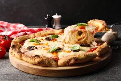 Photo of Taking piece of delicious vegetarian pizza at grey table, closeup