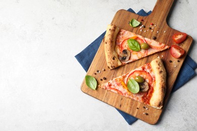 Photo of Cut delicious vegetarian pizza, spices and tomato on light grey table, top view. Space for text