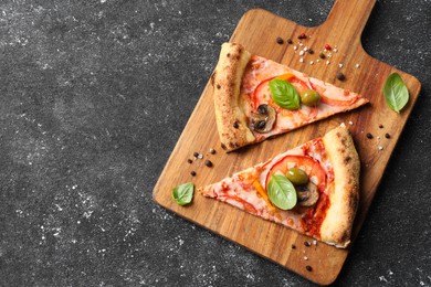 Photo of Cut delicious vegetarian pizza and spices on grey table, top view. Space for text