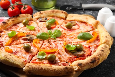 Photo of Cut delicious vegetarian pizza on grey table