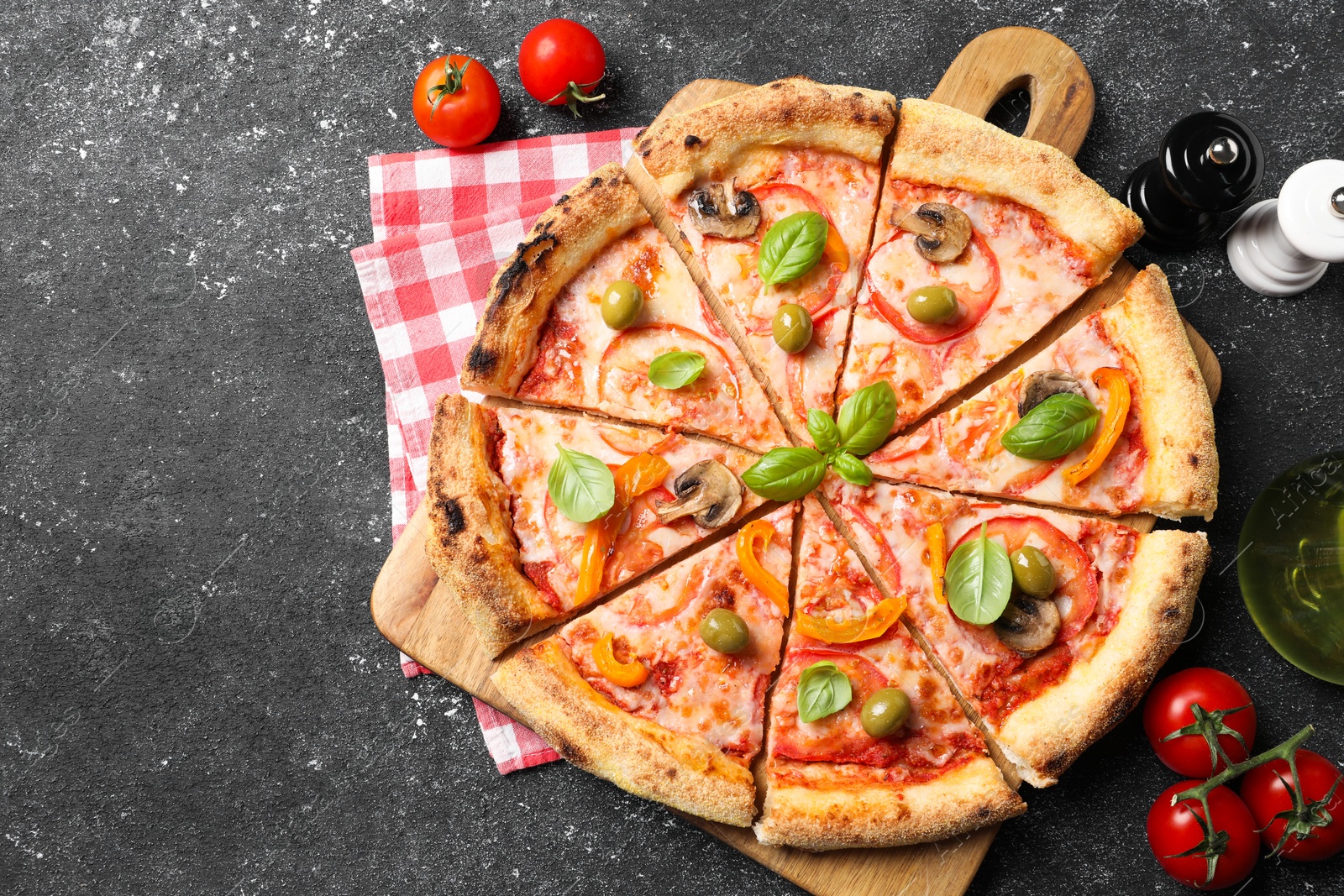 Photo of Cut delicious vegetarian pizza, tomatoes and spices on grey table, top view. Space for text