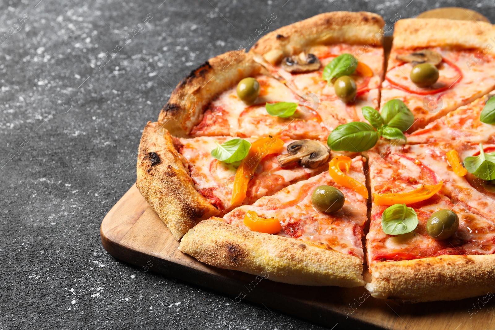 Photo of Cut delicious vegetarian pizza on grey table