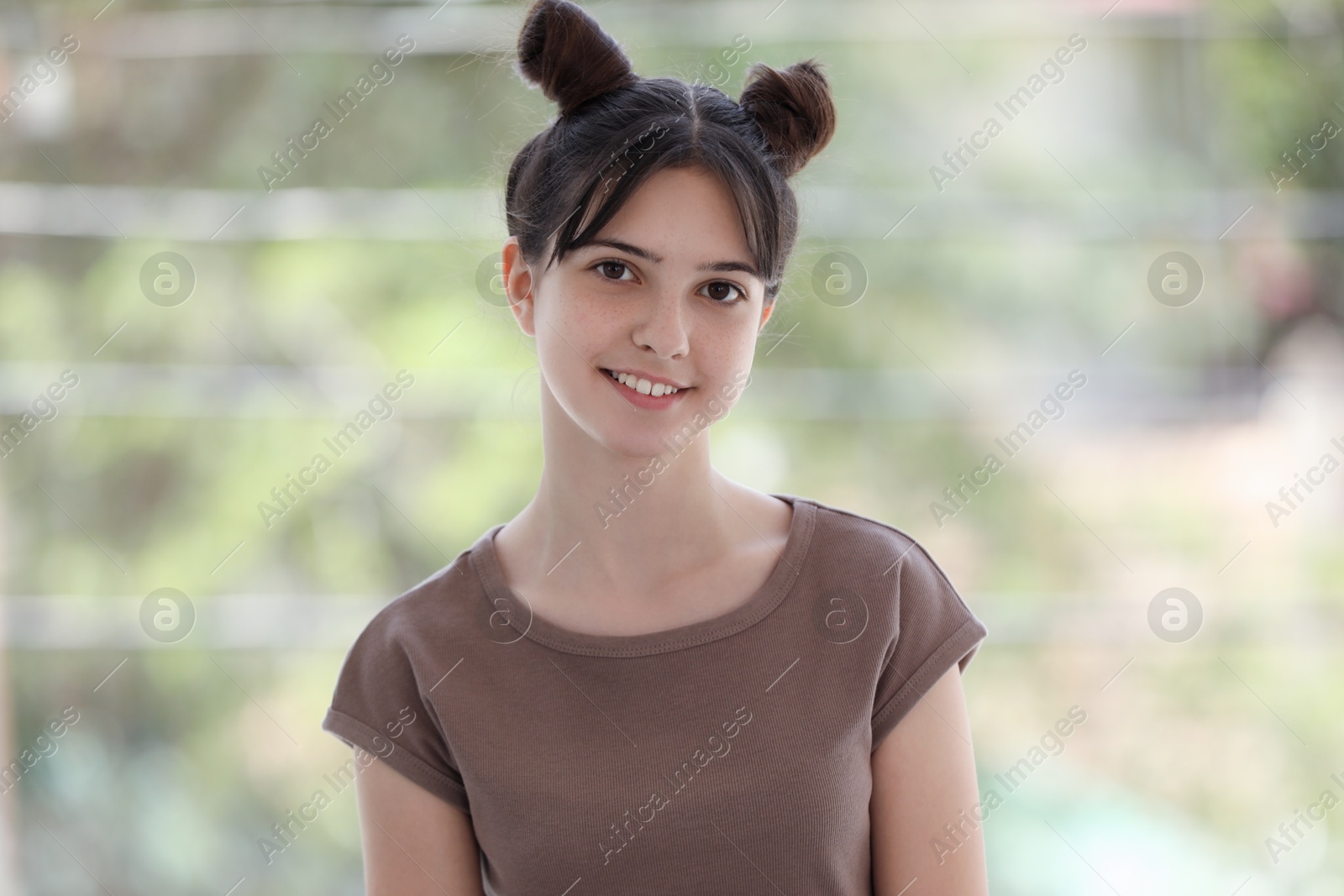 Photo of Portrait of smiling teenage girl on blurred background