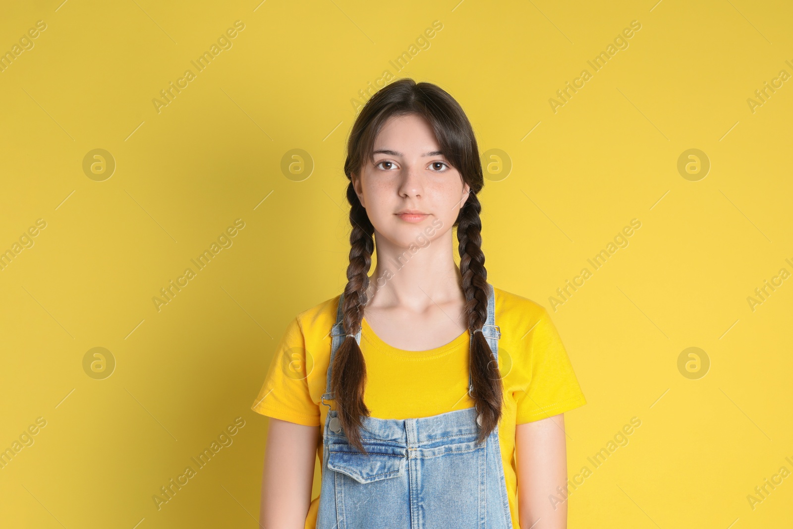 Photo of Portrait of cute teenage girl on yellow background