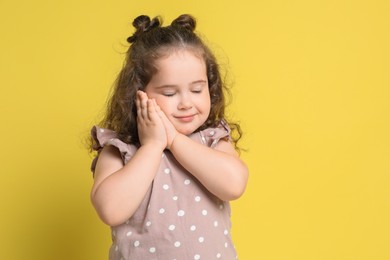 Photo of Portrait of cute girl on yellow background, space for text. Adorable child