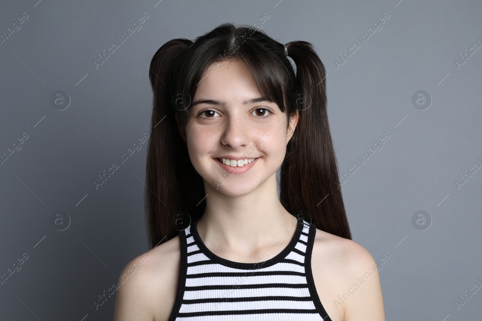 Photo of Portrait of smiling teenage girl on grey background