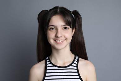 Portrait of smiling teenage girl on grey background