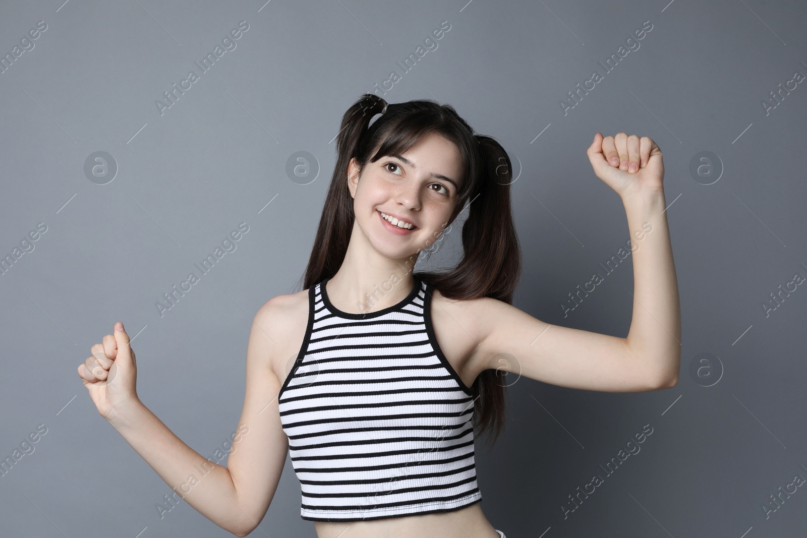 Photo of Portrait of smiling teenage girl on grey background