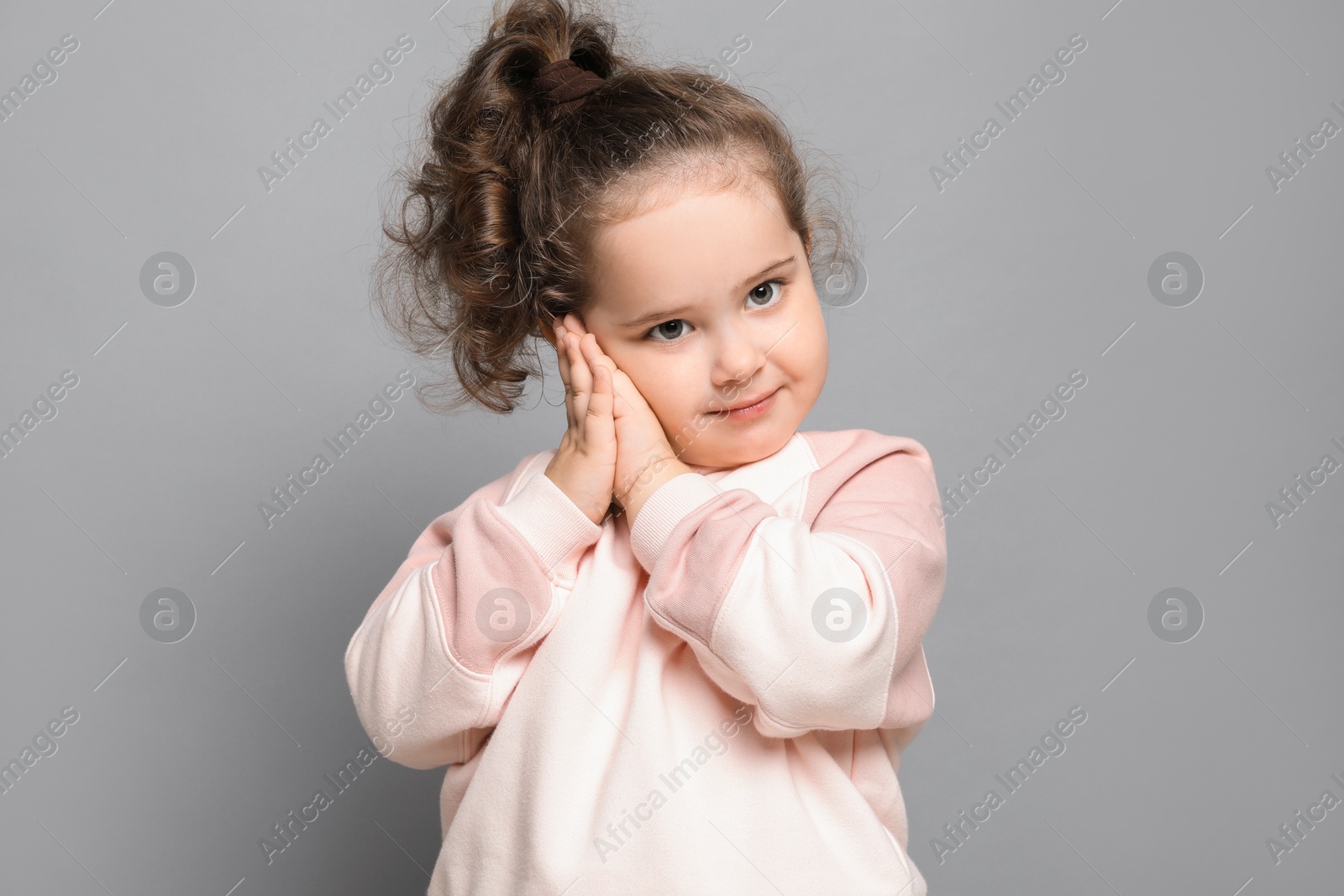 Photo of Adorable child. Portrait of cute girl on grey background