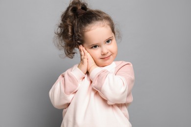 Photo of Adorable child. Portrait of cute girl on grey background