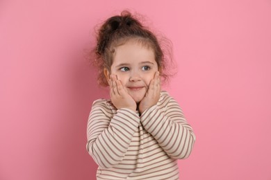 Adorable child. Portrait of cute girl on pink background