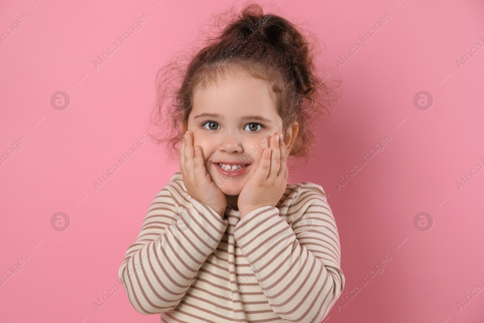 Photo of Adorable child. Portrait of happy girl on pink background