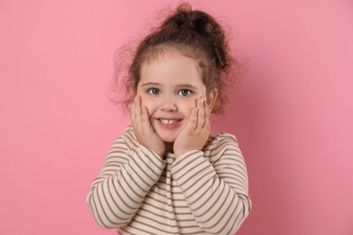 Adorable child. Portrait of happy girl on pink background