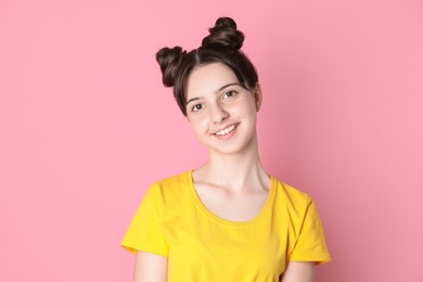 Portrait of smiling teenage girl on pink background