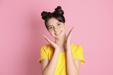 Photo of Portrait of smiling teenage girl on pink background