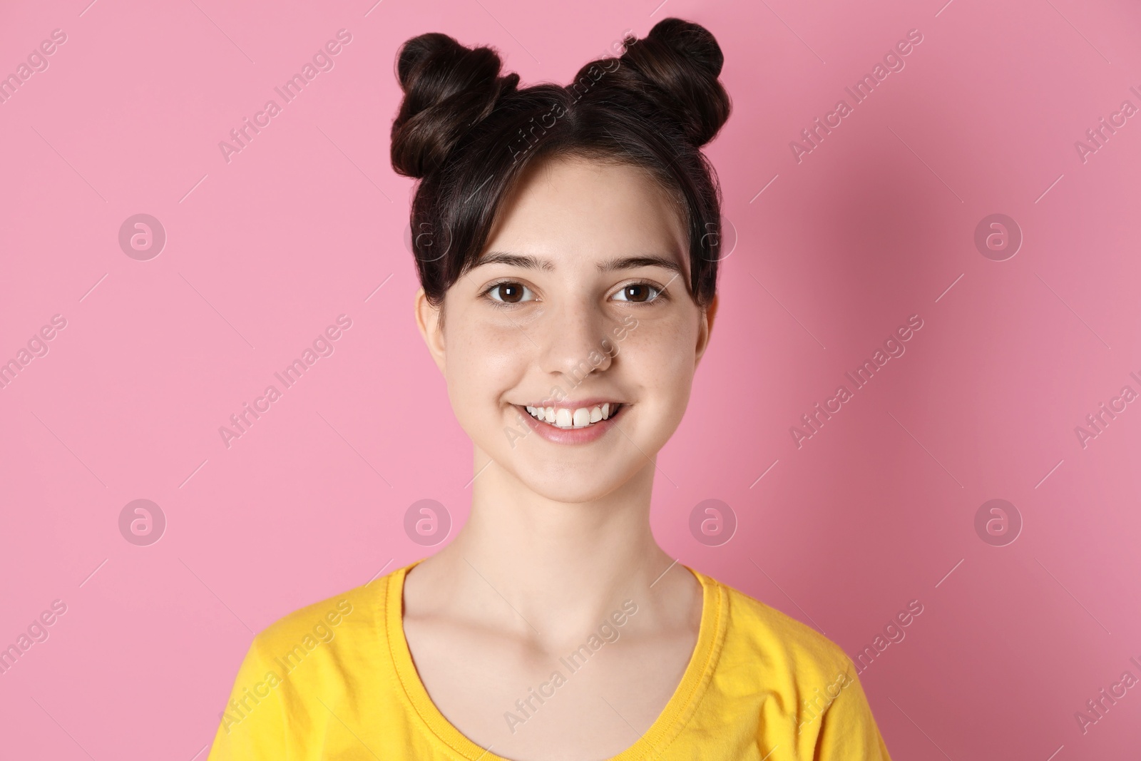 Photo of Portrait of smiling teenage girl on pink background