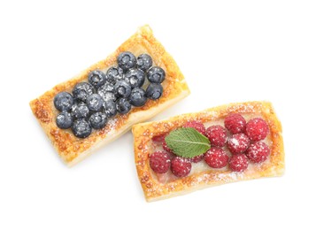 Tasty puff pastries with berries isolated on white, top view