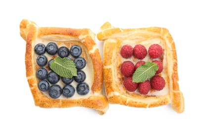 Tasty puff pastries with berries isolated on white, top view