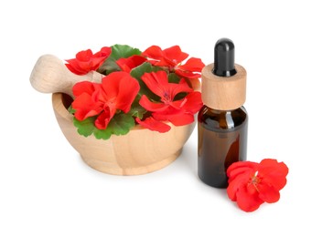 Photo of Bottle of geranium essential oil, mortar and pestle with beautiful flowers isolated on white