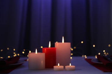 Burning candles on table indoors. Bokeh effect