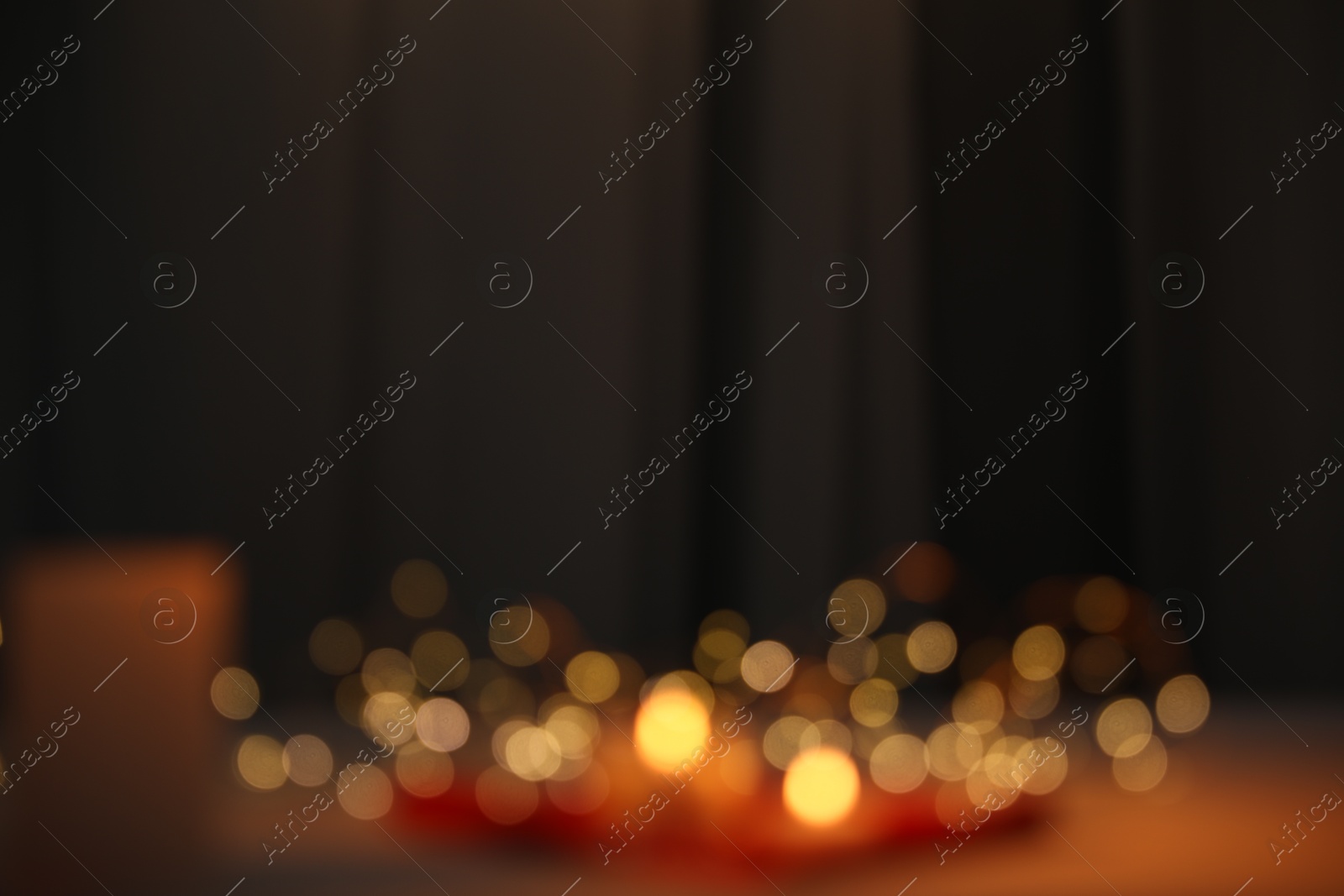 Photo of Blurred view of burning candles indoors. Bokeh effect