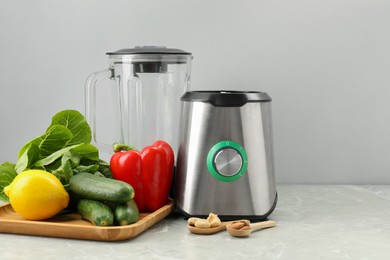 Photo of Blender and healthy products on grey marble table