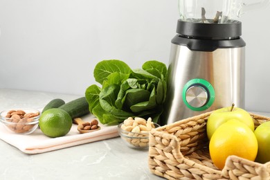 Blender and healthy products on grey marble table, closeup