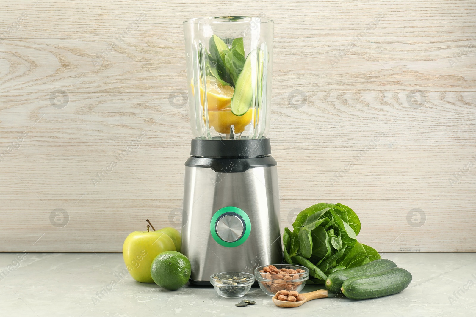 Photo of Blender and products on grey marble table