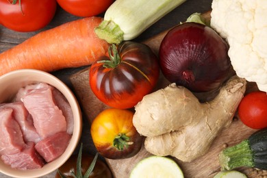 Photo of Different vegetables and raw meat for stew on table, top view