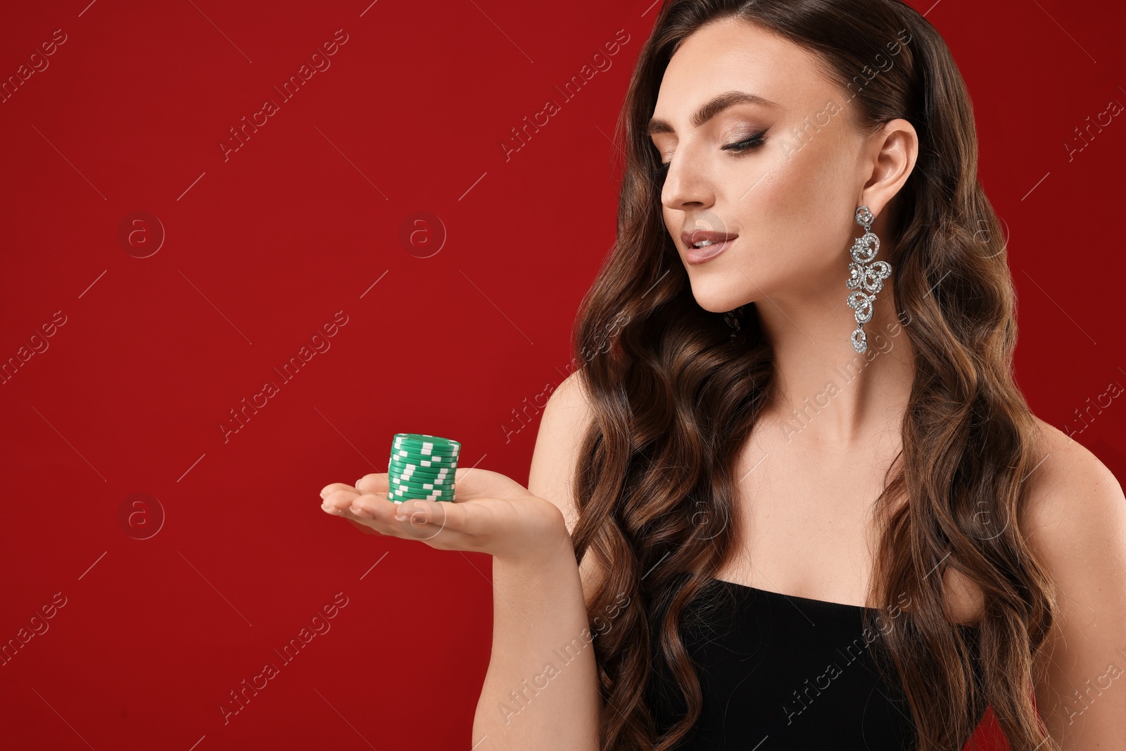 Photo of Charming woman with poker chips on red background. Space for text